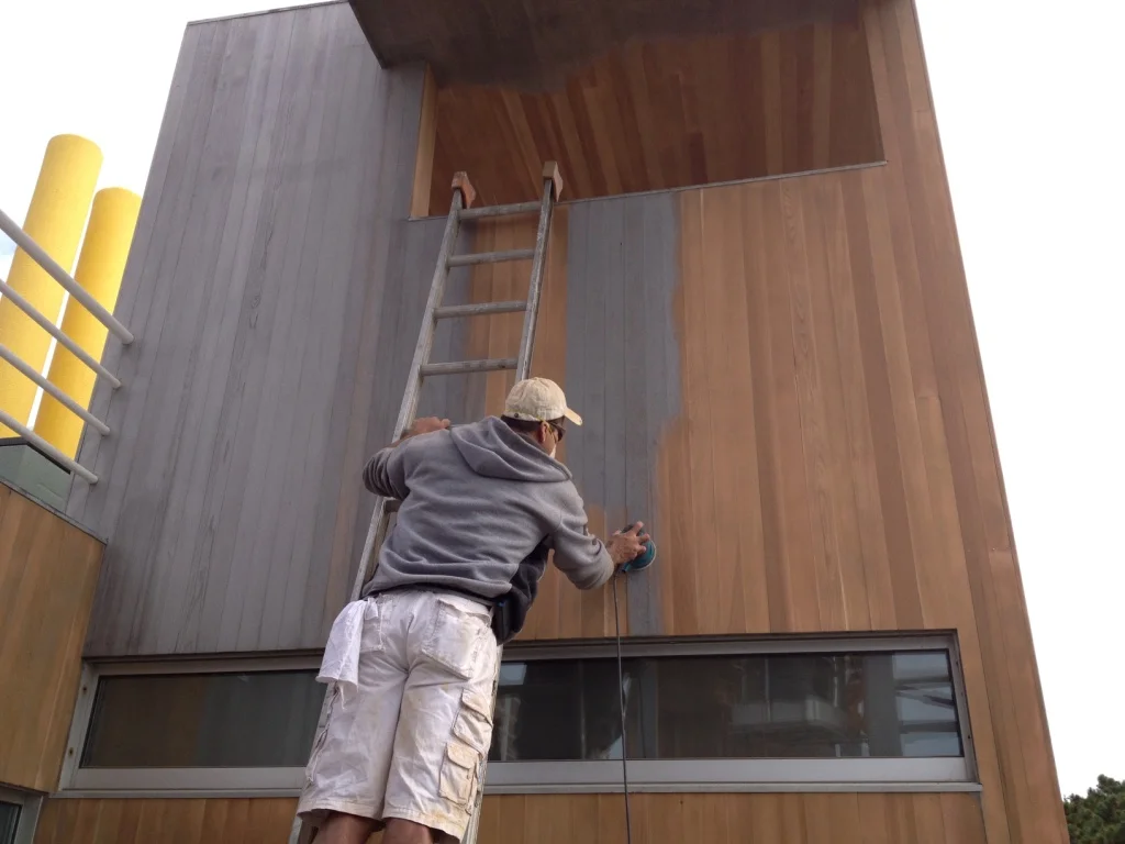 A man is painting the outside of a building