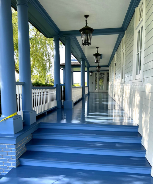 A porch with blue steps and a lamp